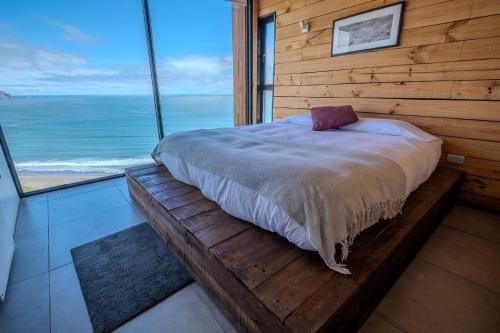 um quarto com uma cama e vista para o oceano em Quadro Matanzas cabañas em Matanzas