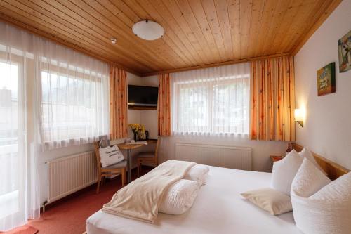 a bedroom with a large white bed in a room at Hotel Garni Dias in Kappl