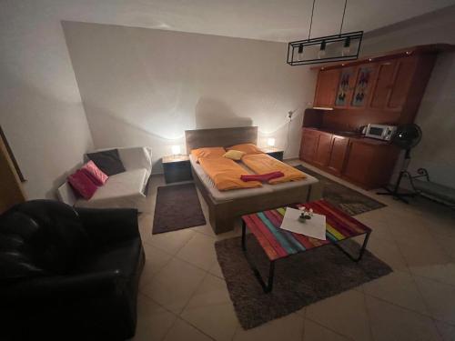 Habitación pequeña con cama y sofá en Monelly Apartman, en Komárno