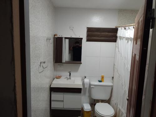 uma casa de banho com um WC, um lavatório e um espelho. em Casa Laurel em Puerto Iguazú