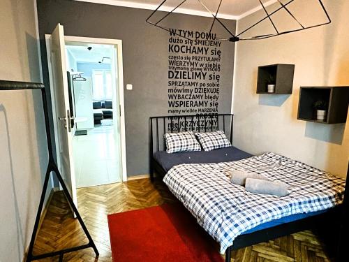 a bedroom with a bed with a sign on the wall at Apartament Vincent in Toruń