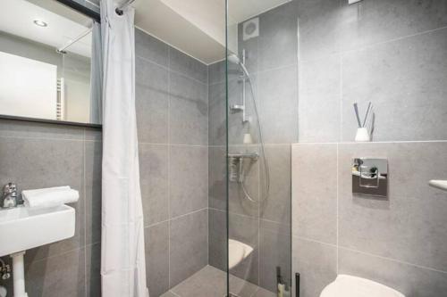a bathroom with a shower and a toilet and a sink at Vesturgata in Reykjavík