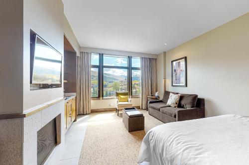 a hotel room with a bed and a couch and a tv at Eagle River by AvantStay Located in the Westin in Avon