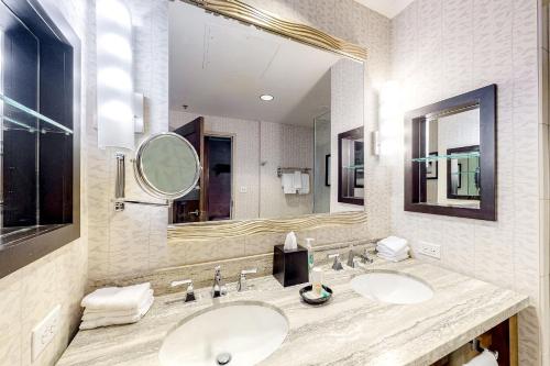 uma casa de banho com 2 lavatórios e um espelho grande em Eagle River by AvantStay Located in the Westin em Avon