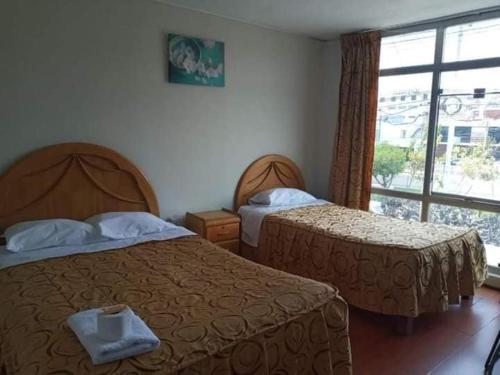 a hotel room with two beds and a window at HOTEL AREQUIPA ANDINOS in Arequipa