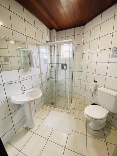 a bathroom with a toilet and a sink and a shower at Real NOB Hotel in Orleans