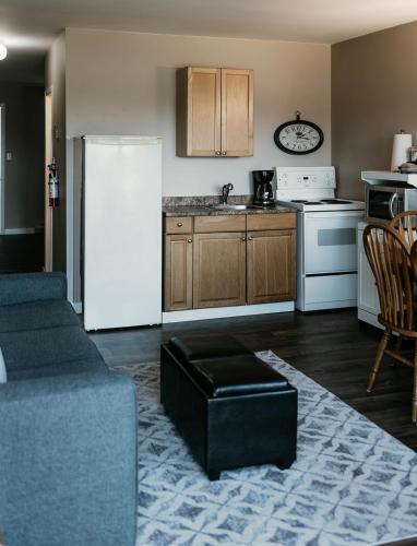 a kitchen with a refrigerator and a couch and a table at Page's Inn on Silva Bay in Gabriola