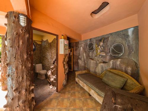 蘇梅島的住宿－Натуральные виллы в тропическом саду，客房设有沙发和带卫生间的墙壁。