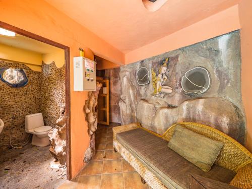 a bathroom with a stone wall with a toilet at Натуральные виллы в тропическом саду in Koh Samui