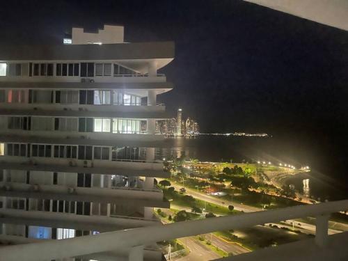 widok na budynek w nocy z oceanem w obiekcie Hermoso Apartamento con una de las mejores vistas w Panamie