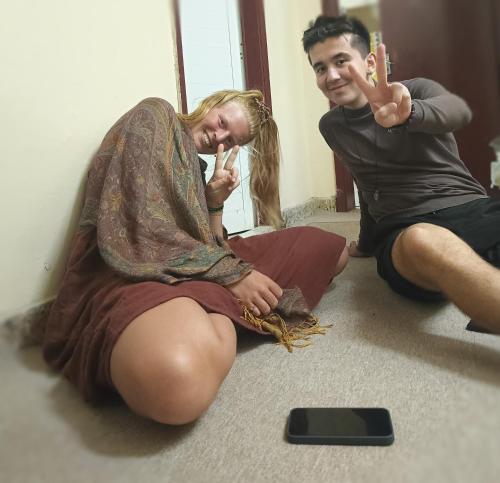 a man and a woman sitting on the floor at orange hostel in Dubai