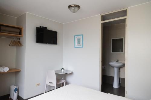 a bedroom with a bed and a sink and a mirror at San Miguel Awanka Hotel in Lima