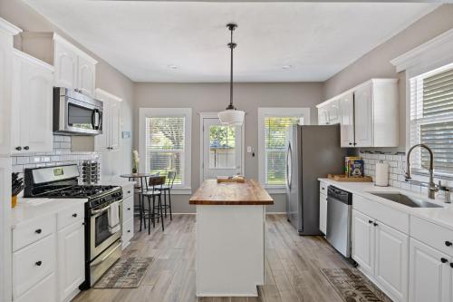 a kitchen with white cabinets and a kitchen island at Charming Craftsman close by Bishop Arts & Downtown in Dallas