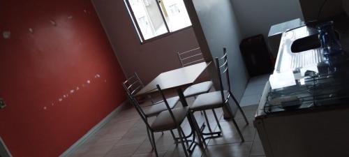 a kitchen with a table and chairs and a window at Aptos Farroupilha in Farroupilha