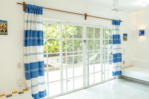 a room with a large window with blue and white curtains at Casa Mazunte Tierra Viva in Mazunte