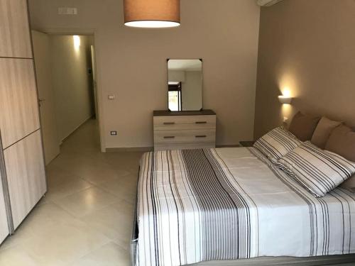 een slaapkamer met een bed, een dressoir en een spiegel bij Il Belvedere di Nonna Vincenza - Taormina side in Piedimonte Etneo