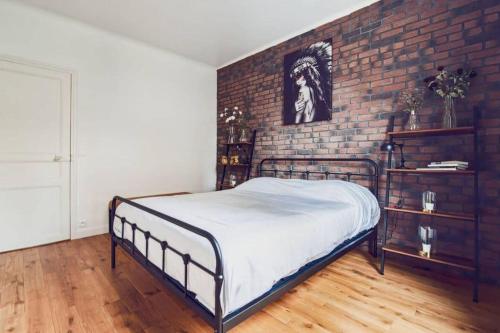 a bed in a room with a brick wall at Studio Cosy Tout Confort Porte Orléans 2 Pers Paris in Montrouge