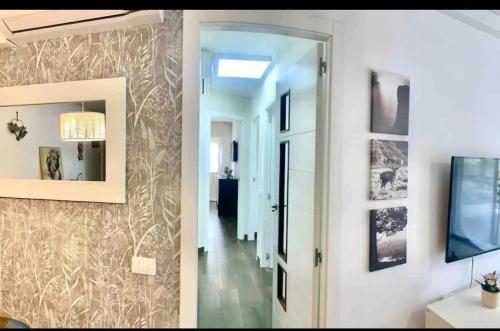 two pictures of a hallway with a mirror and a hallway with a television at Cristimar H23 big pool, 3 bedroom and 3 baths in Los Cristianos