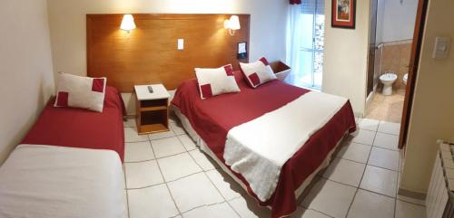 a hotel room with two beds and a bathroom at Hotel Francia in Tandil