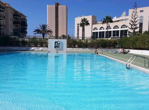 a large blue swimming pool with buildings in the background at Cristimar H23 big pool, 3 bedroom and 3 baths in Los Cristianos