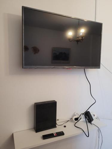 a television on a wall above a desk with a laptop at Hermoso departamento 2 amb sobre Avenida Maipu in Vicente López