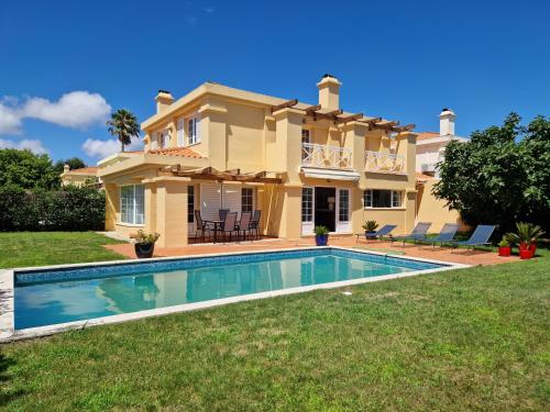 a villa with a swimming pool in front of a house at RENT4REST GOLF LOVERS PARADISE 4BR VILLA WITH Pool in Sintra