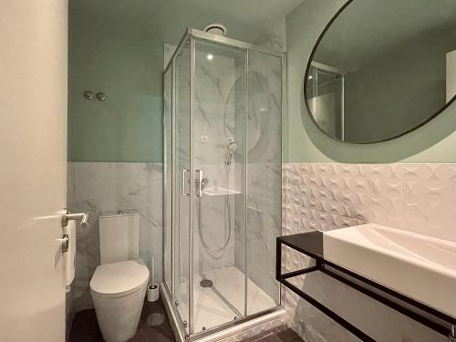 a bathroom with a shower and a toilet and a sink at Avenue Hostel & Suites in Lisbon
