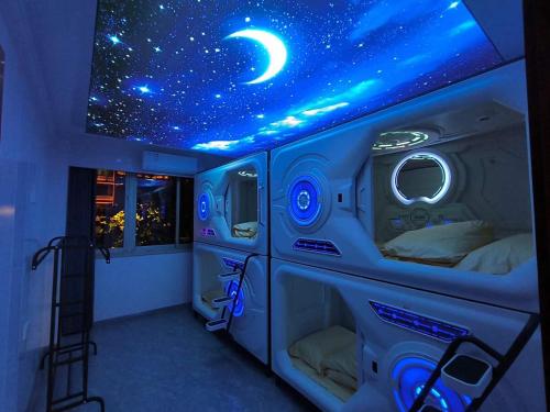 a room with a bed with a moon and stars on the ceiling at bambu hostel capsules in Seville