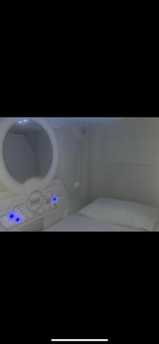 ein weißes WC mit blauen Lichtern im Bad in der Unterkunft bambu hostel capsules in Sevilla