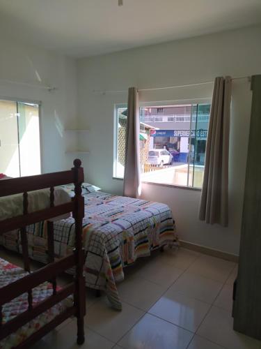 a bedroom with a bed and a window at Imóvel com 02 quartos próxima ao Morro do Macaco in Bombinhas