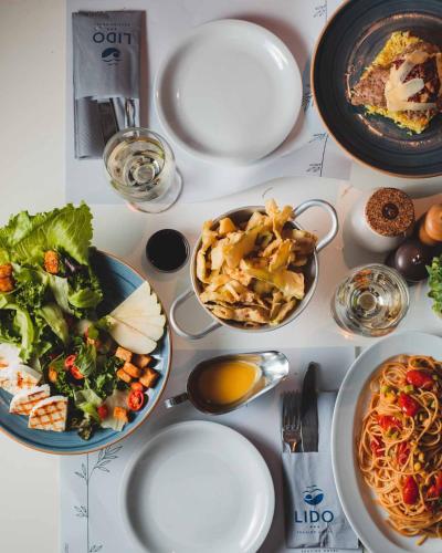 a white table with plates of food on it at Lido Hotel in Xylokastron