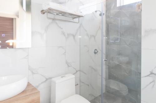 uma casa de banho branca com um WC e um chuveiro em Hotel San Lorenzo em Moquegua
