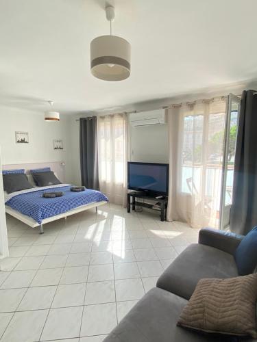 ein Wohnzimmer mit 2 Betten und einem Flachbild-TV in der Unterkunft Appartement confortable près de la plage Catalane et Pharo in Marseille