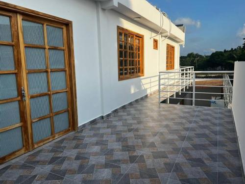 - un balcon d'une maison avec une porte et un sol dans l'établissement Apt 2 Hab con Piscina Privada! Cerca a Playa, à San Antero
