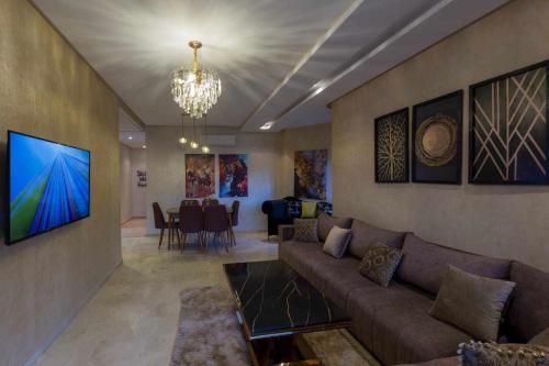 a living room with a couch and a dining room at Prestigia golf city porte agate in Marrakech