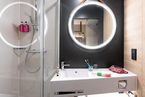 a bathroom with a white sink and a mirror at Moxy Plymouth in Plymouth