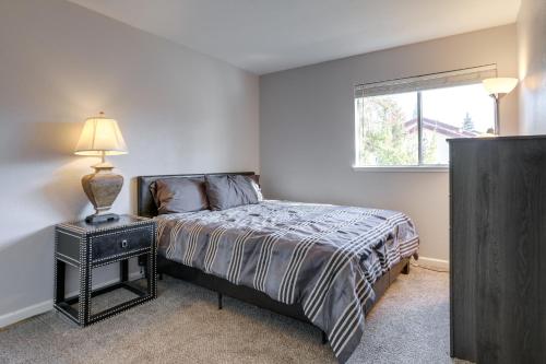 Un dormitorio con una cama con una lámpara y una ventana. en Pet-Friendly Citrus Heights Home Fenced Backyard!, en Citrus Heights