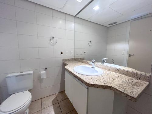 a bathroom with a toilet and a sink at Apartamento no Mercure - canal 3 in Santos