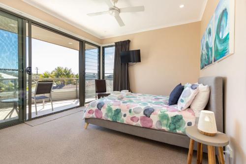 a bedroom with a bed and a balcony at Boom 1 in Blueys Beach