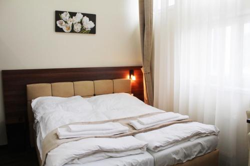 a bed with white towels on it in a bedroom at Elite Pension in Štúrovo