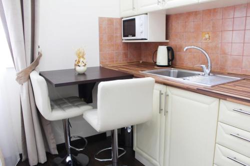 a small kitchen with a sink and a table at Elite Pension in Štúrovo