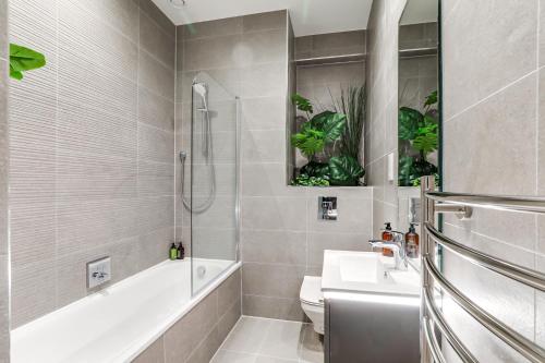 y baño con bañera, lavabo y aseo. en Modern 2BR 2BA with Free Parking - Sleeps 6 en Hemel Hempstead