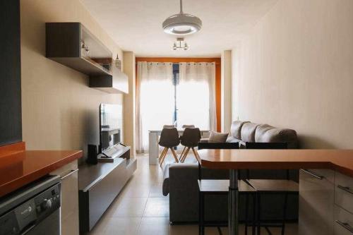 eine Küche und ein Wohnzimmer mit einem Sofa und einem Tisch in der Unterkunft Frente a Puerto Azahar 3 in Grao de Castellón