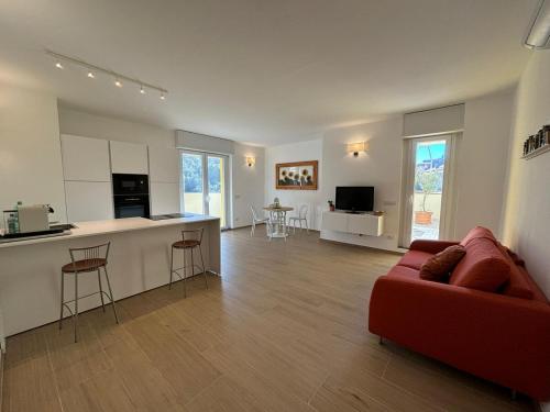 a living room with a red couch and a kitchen at La Terrazza di Mimì in Levanto