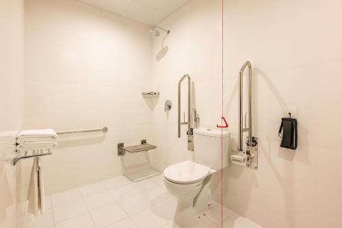a white bathroom with a toilet and a shower at Marriott Executive Apartments City Center Doha in Doha