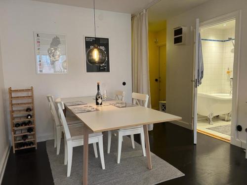 ein Esszimmer mit einem Tisch, Stühlen und einer Badewanne in der Unterkunft Apartment in the middle of So-Fo, Södermalm, 67sqm in Stockholm