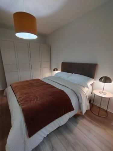 une chambre avec un grand lit avec une couverture marron dans l'établissement Charmant App Grand'Rue vieille ville, à Strasbourg