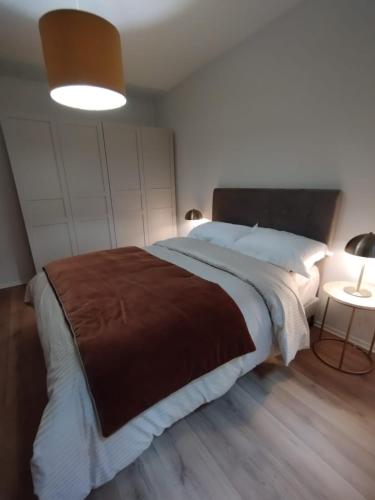 une chambre avec un grand lit avec une couverture marron dans l'établissement Charmant App Grand'Rue vieille ville, à Strasbourg