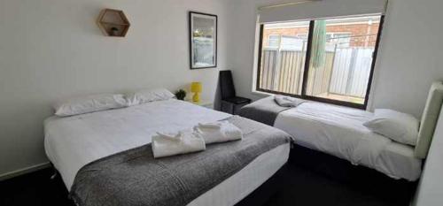 a bedroom with two beds and a window at Allure Apartments - Central in Mildura
