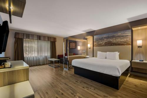 Best Western Diamond Bar Hotel & Suites في دياموند بار: غرفة الفندق بسرير كبير ومكتب